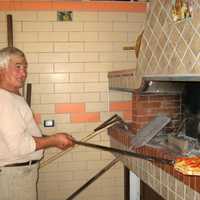 Man putting Pizza in the oven