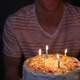 Person holding Birthday Cake with four candles