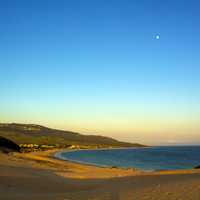 Beach landscape with moon in blue sky
