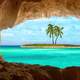 Viewing a tropical island and Palm tree through a cave