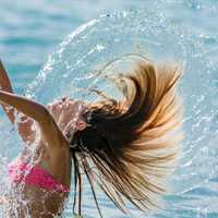 girl-in-pink-bathing-suit-slinging-hair-and-water