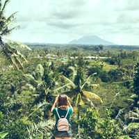 Woman traveler taking pictures of Batur volcano, tropical island