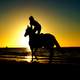 person-riding-horse-into-the-sunset
