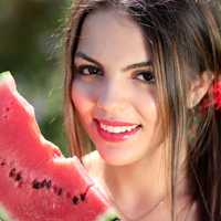 Pretty young woman eating watermelon