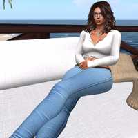 Woman in white shirt and jeans relaxing by the seaside