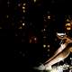 young-women-sitting-at-night-looking-at-small-lights