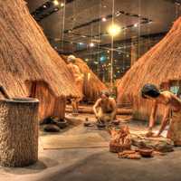 Native Americans working besides houses at Cahokia Mounds, Illinois