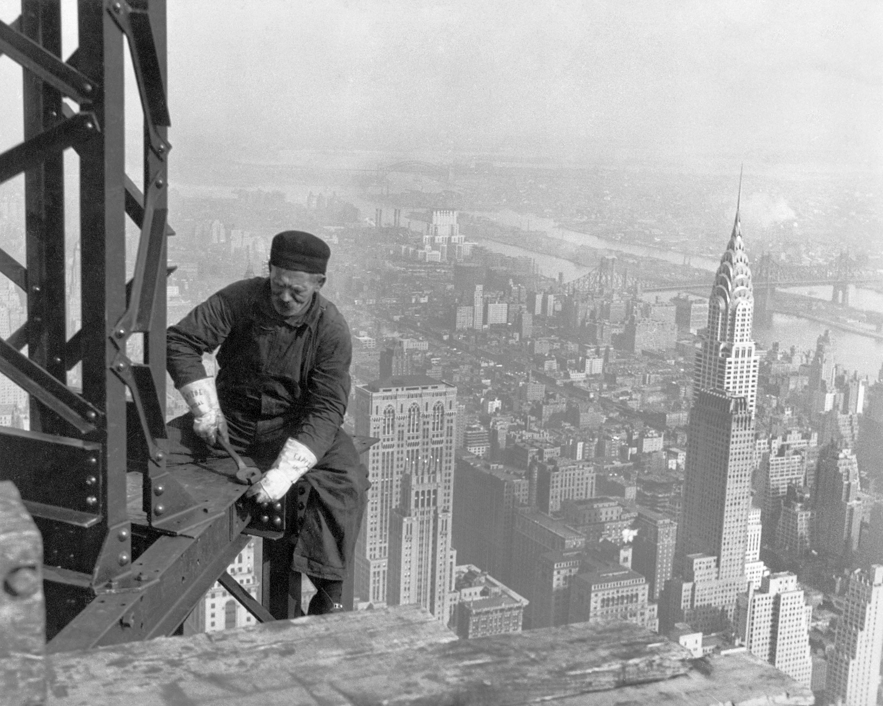 A construction worker on top of the Empire State Building as it was