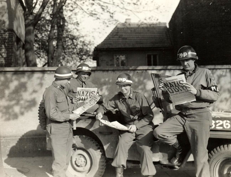 Us Military Policemen Read About The German Surrender Ending World War